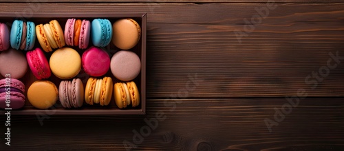 A copy space image featuring a box of macaroons placed on a wooden background