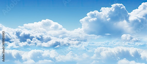 The image captures a panoramic view of the expansive blue sky with scattered fluffy clouds copy space image