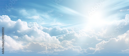 An abstract background featuring a sunny summer sky with white clouds and a subtle flare of light providing ample room for including text or images