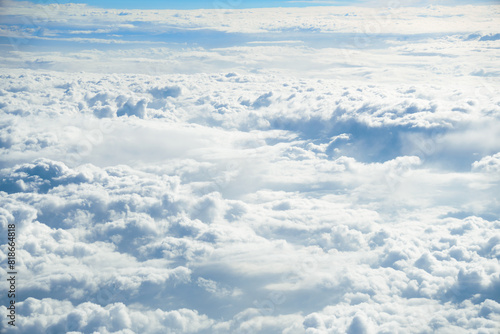 Top view of fluffy clouds from an airplane window