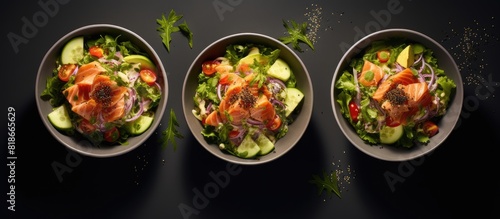 A copy space image of poke salad with tuna and green vegetables in bowls viewed from above against a gray background