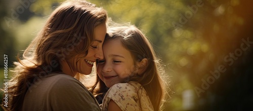 A mother and her daughter embrace in a park sharing a moment filled with joy and closeness The image offers copy space photo