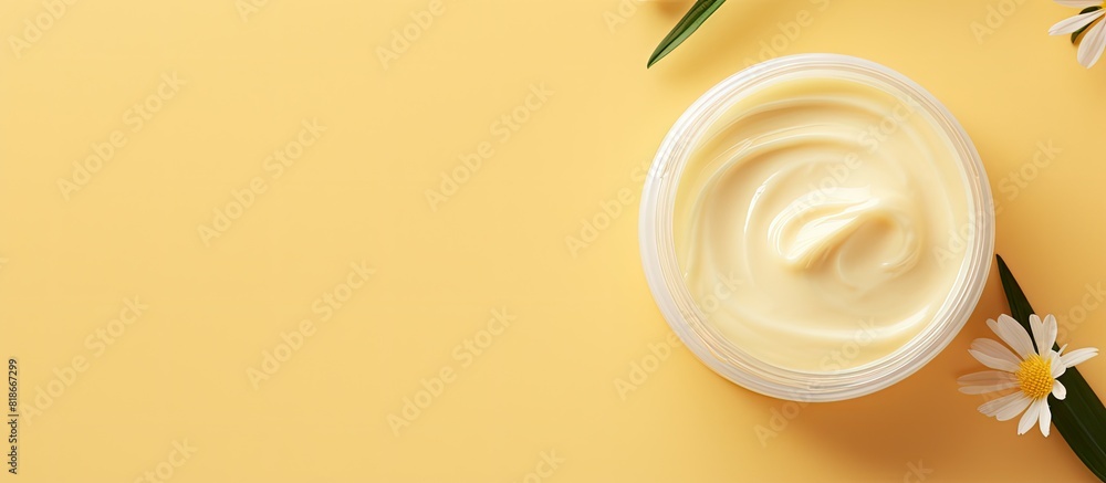 A jar of body butter is placed on a yellow background to create a copy space image This image represents a skin care product a natural cosmetic and the concept of cream The view is from the top with a A jar of body butter is placed on a yellow background to create a copy space image This image represents a skin care product a natural cosmetic and the concept of cream The view is from the top with a