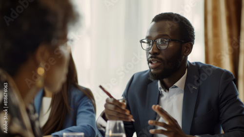 Professional in a suit engages in a persuasive conversation at a sunlit meeting.