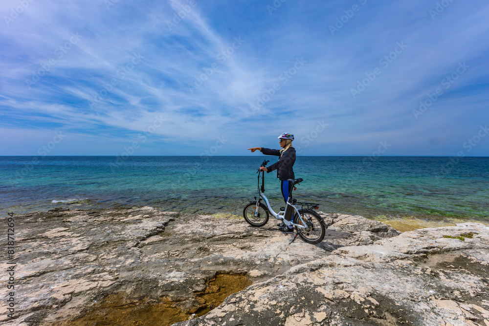 Fototapeta premium Discharged battery in an electric bike, a woman in a helmet is looking for an electric bike charger in Croatia