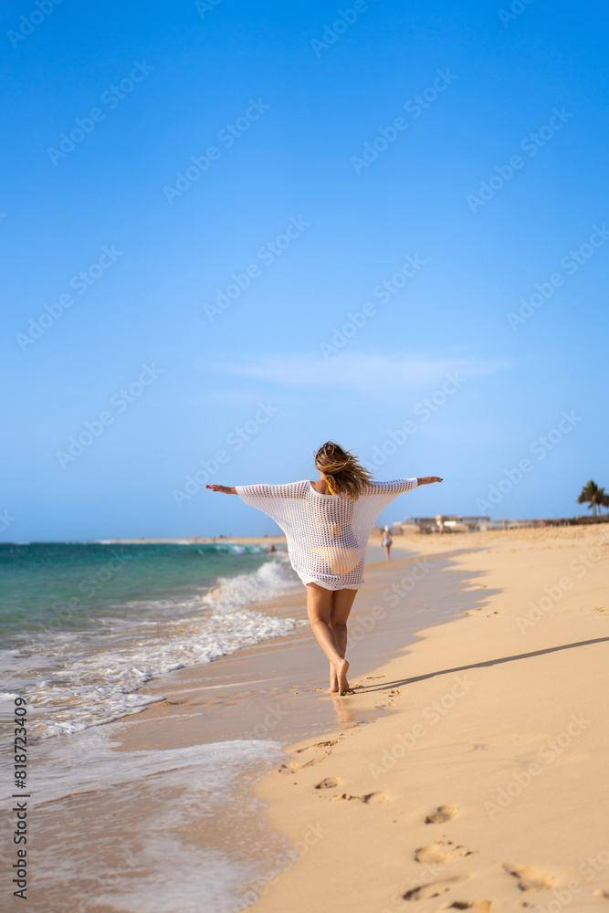 Beautiful woman with arms raised and outstretched walking on sunny beach
Beautiful woman with arms raised and outstretched walking on sunny beach