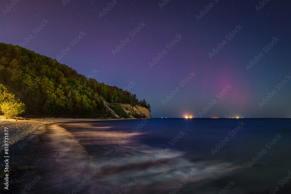 Baltic cliff in Gdynia Orlowoat night with Northerm lights over the sea. Poland
