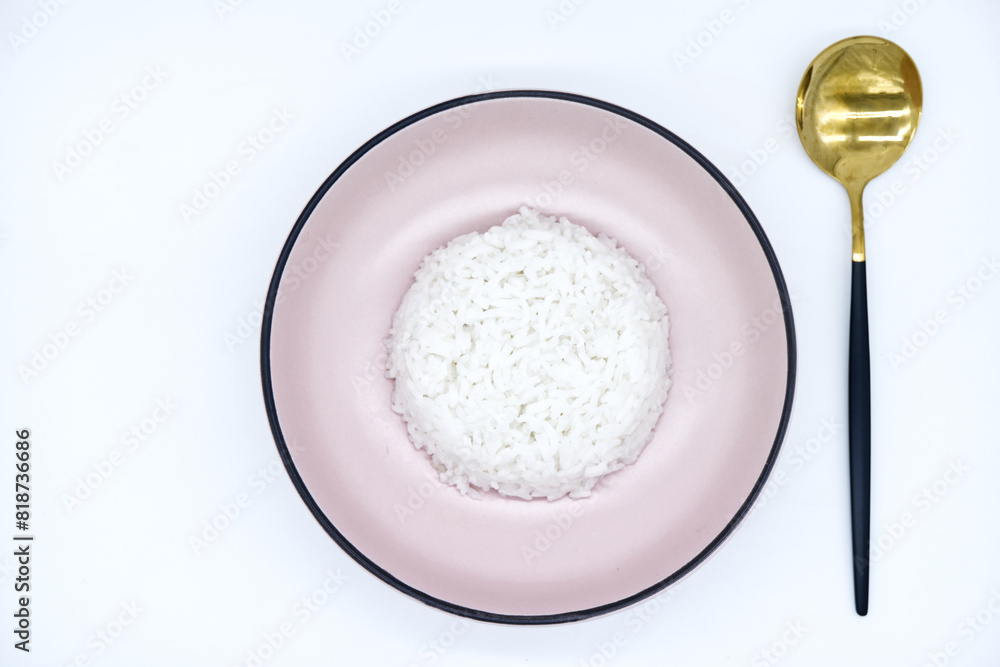 Cooked rice in a pink bowl with a spoon placed on a white background. Cooked rice top view with copy space for meals, vegan, healthy food, and cooking concepts. Close-up of fresh jasmine rice texture. Cooked rice in a pink bowl with a spoon placed on a white background. Cooked rice top view with copy space for meals, vegan, healthy food, and cooking concepts. Close-up of fresh jasmine rice texture.