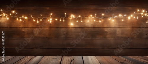 A festive scene of Christmas decorations illuminated by twinkling lights on a rustic wooden backdrop creating a perfect copy space image