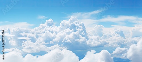 In the summer sky large white fluffy clouds float amidst a backdrop of clear brilliant blue Copy space image
