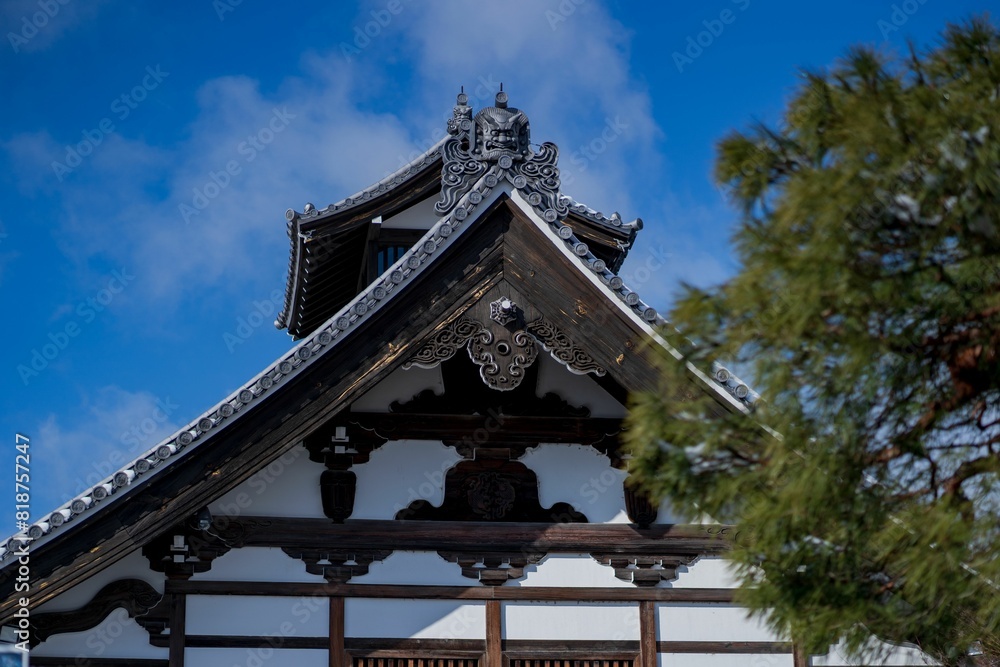 Snow-covered roof of a japanese temple under clear blue sky in a wintry landscape Snow-covered roof of a japanese temple under clear blue sky in a wintry landscape