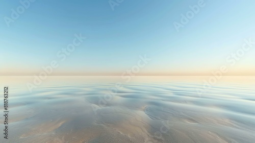 The image is a beautiful landscape of a beach with a calm sea. The sky is clear and blue  and the sun is shining brightly.