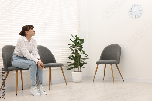 Woman sitting on chair and waiting for appointment indoors