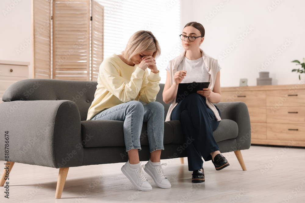 Professional psychotherapist working with on sofa patient in office Professional psychotherapist working with on sofa patient in office