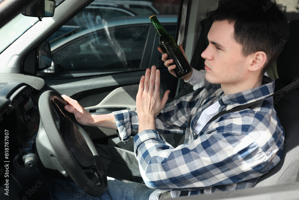 Driver refusing from alcohol while woman suggesting him beer in car, closeup. Don't drink and drive concept