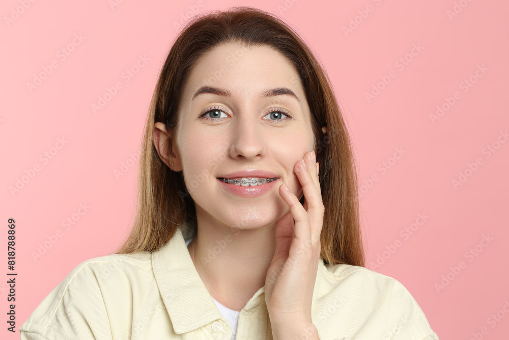 Portrait of smiling woman with dental braces on pink background Portrait of smiling woman with dental braces on pink background