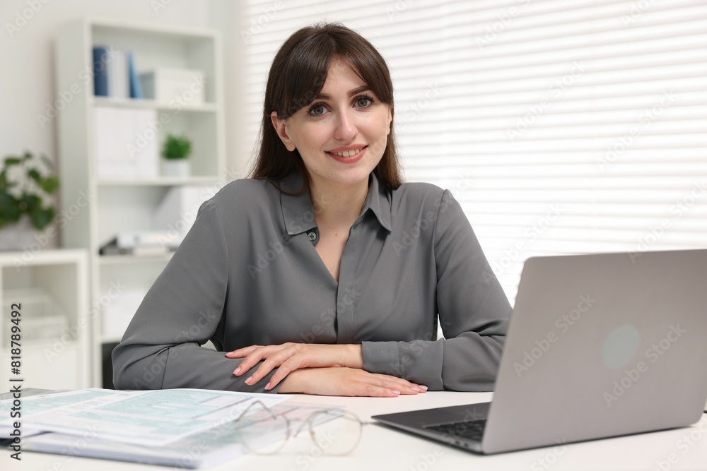 Portrait of smiling secretary at table in office Portrait of smiling secretary at table in office