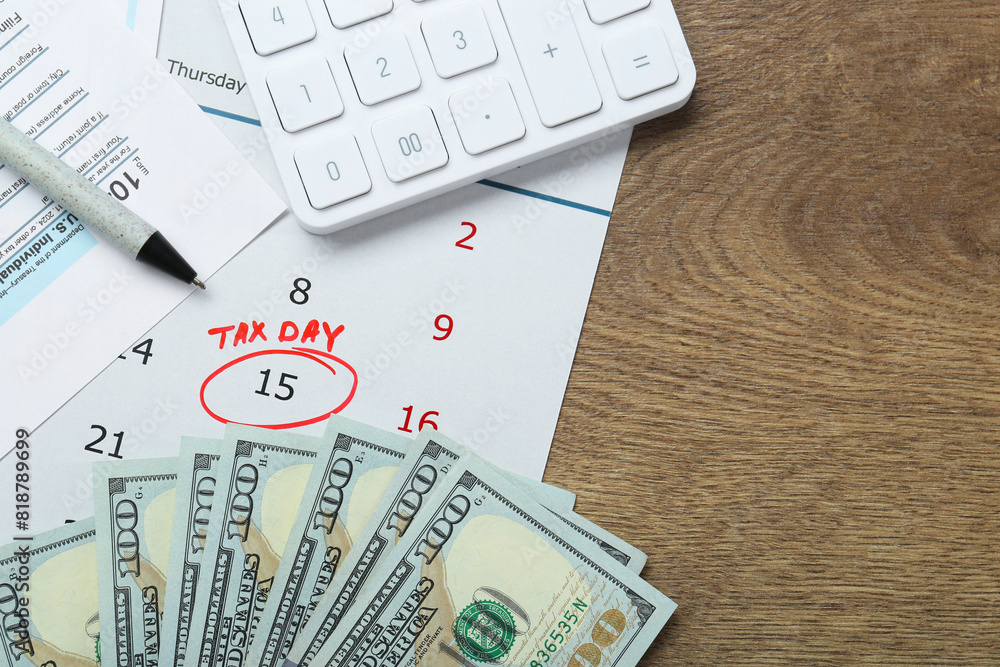 Calendar with date reminder about tax day, documents, pen, money and calculator on wooden table, flat lay. Space for text Calendar with date reminder about tax day, documents, pen, money and calculator on wooden table, flat lay. Space for text