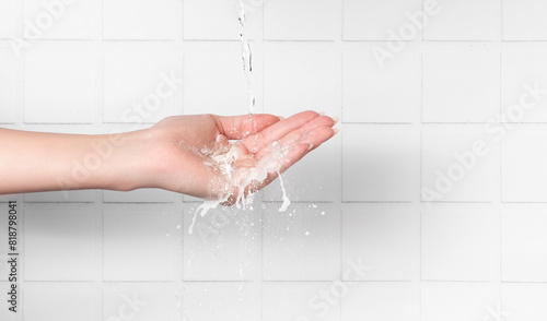 Female hand washing with water on white background