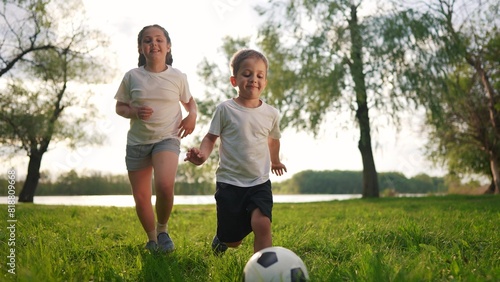 kid children play in soccer with his family in the park. happy family kid dream concept. The children are playing ball in the park. a group of summer children playing ball on the grass in forest
