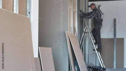Contractor Worker on Ladder Inside Building. Drywall Wall Construction.