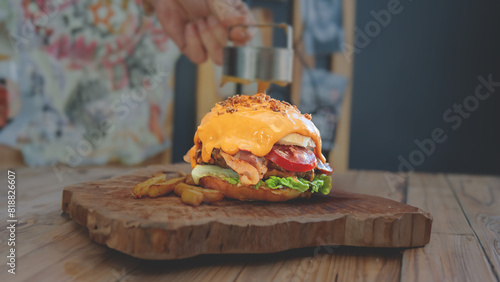 tasty hamburger topped with cheddar cheese, dark background