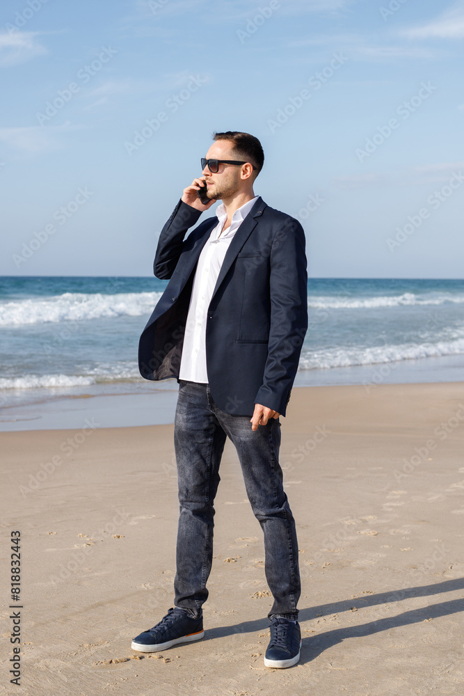 Young businessman on the phone at beach. Freedom, vacation or stress free concept Young businessman on the phone at beach. Freedom, vacation or stress free concept