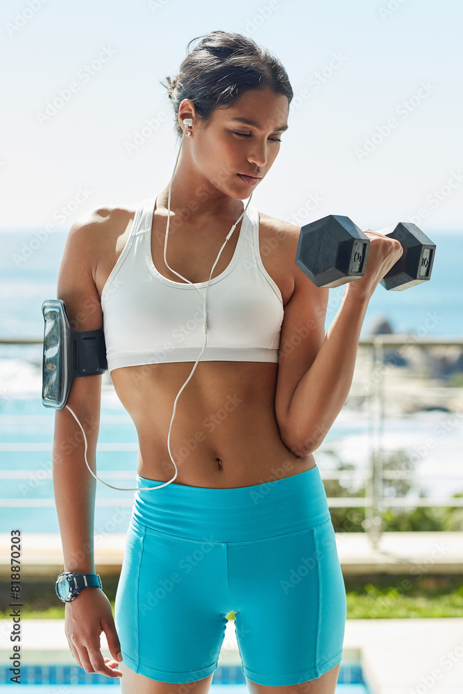 Indian girl, earphones and dumbbell for workout in outdoor, bicep and training for muscle growth. Female person, confident and music for weight lifting, strong body and sound for power or health Indian girl, earphones and dumbbell for workout in outdoor, bicep and training for muscle growth. Female person, confident and music for weight lifting, strong body and sound for power or health