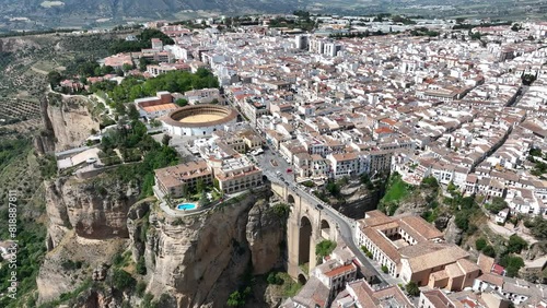 Cinematic aerial video of historic houses built on the edge of the cliff with bridge and waterfall in Ronda, Spain