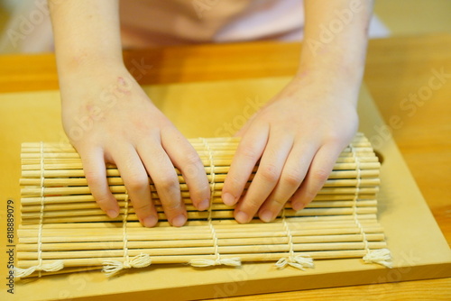 節分の日。張り切って恵方巻きを作ってくれている小学2年生の女の子。作っている手元の様子。