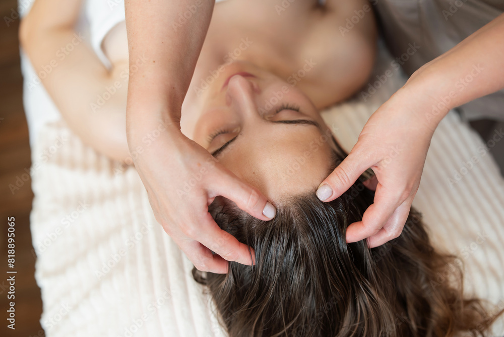 Fototapeta premium Beautiful young woman getting face massage in professional salon, close up. Relaxing, caring about body and skin, enjoying pleasant spa procedure