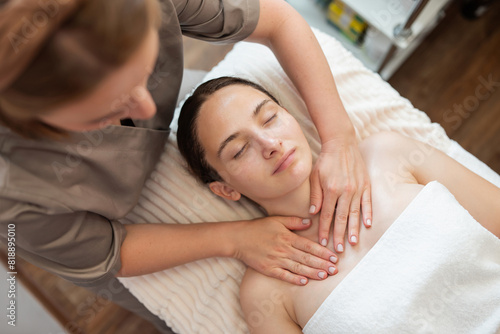 Young woman getting spa massage treatment at beauty salon. Concept of skin and body care, facial treatment and cosmetology