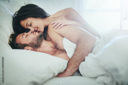 Romance, morning and couple in bed with kiss, love and happy bonding in apartment. Relationship, man and woman relax in bedroom with intimate embrace, passion and wake up with care on weekend in home