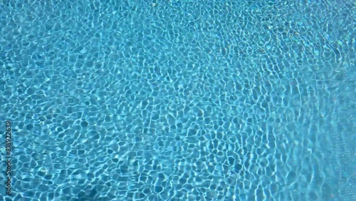 Clear Blue Pool Water with Sunlight Reflections and Ripple Patterns. 4K Video