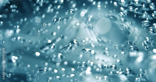 Many water bubbles in blue water close up, abstract water wave with bubbles in slow motion.