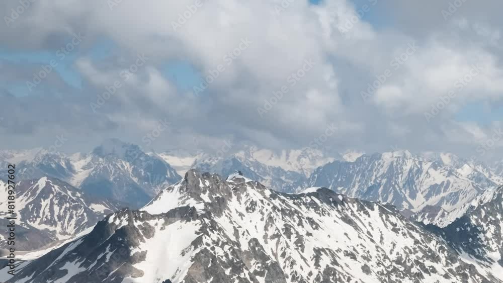 Air flight through mountain clouds over beautiful snow-capped peaks of mountains and glaciers. Air flight through mountain clouds over beautiful snow-capped peaks of mountains and glaciers.