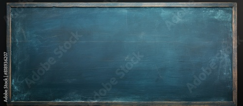 A dark blue chalkboard with traces of erasing featuring a full surface frame and a textured background Copy space image
