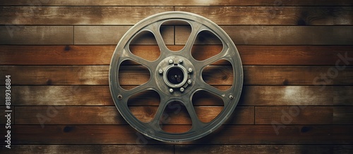 Vintage film reel displayed on a bright wooden backdrop Ideal for wallpapers and can be used as a copy space image photo