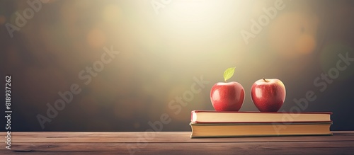 An apple is resting on top of a stack of books creating a copy space image that symbolizes the concept of education and going back to school photo