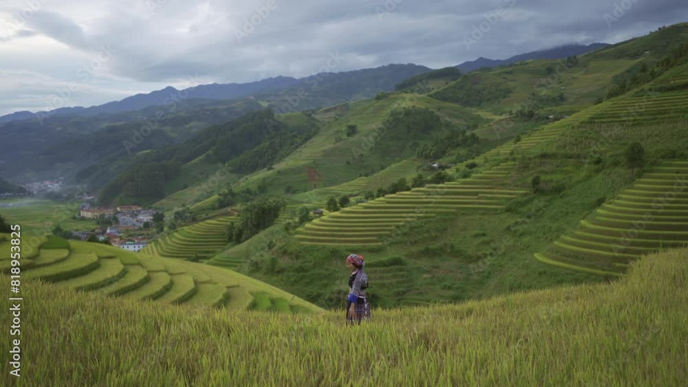 A farmer woman with fresh paddy rice terraces, green agricultural fields in countryside or rural area of Mu Cang Chai, mountain hills valley in Asia, Vietnam. Nature landscape. People lifestyle. A farmer woman with fresh paddy rice terraces, green agricultural fields in countryside or rural area of Mu Cang Chai, mountain hills valley in Asia, Vietnam. Nature landscape. People lifestyle.