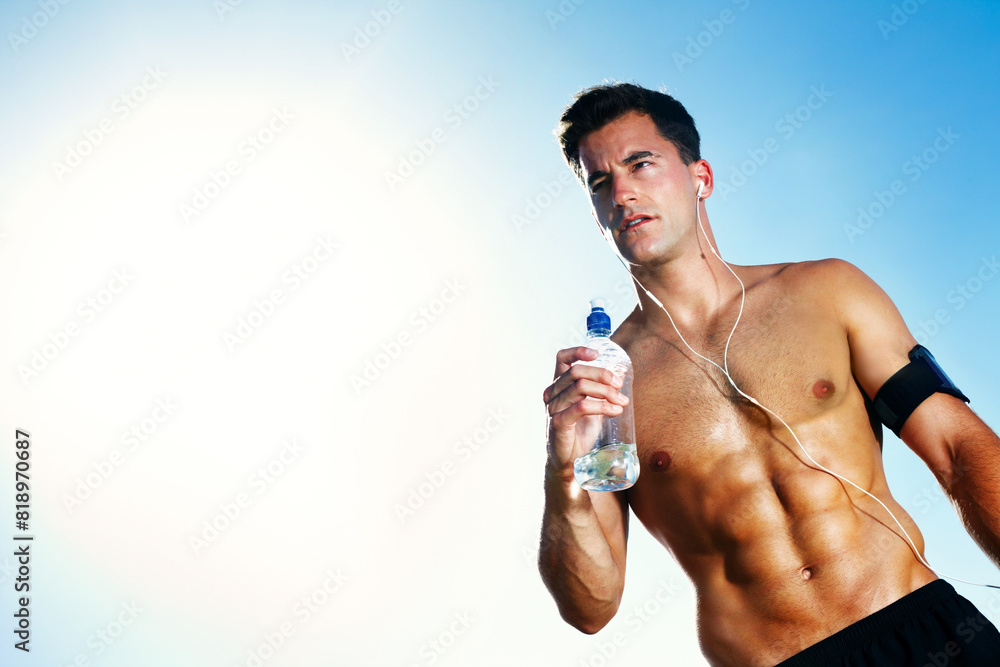 Fototapeta premium Water, tired and man on field for workout, earphones and portrait with bottle and summer. Training, cardio and exercise for male person or athlete, running or park for fitness with music and sunlight