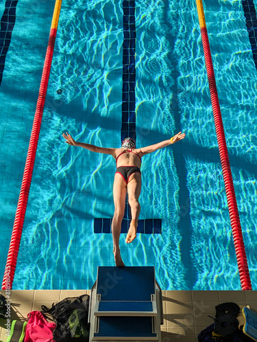 Swimmer girl start from the starting table in the pool