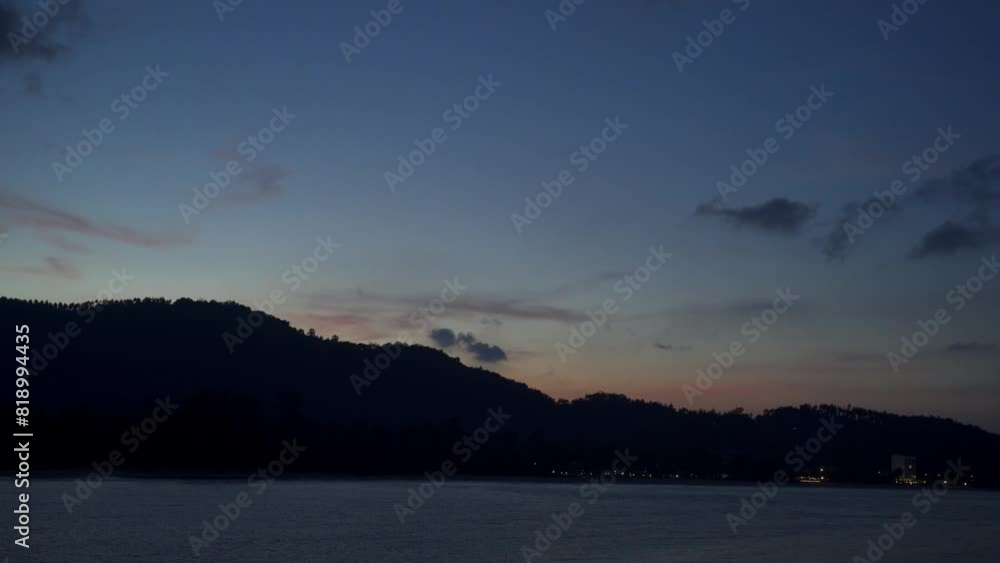 The sun sets in the evening with the sea and mountains behind and the lights of the houses slowly panning from bottom to top The sun sets in the evening with the sea and mountains behind and the lights of the houses slowly panning from bottom to top