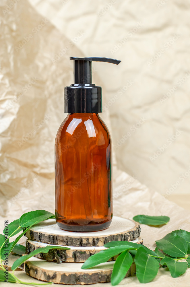Brown cosmetic bottle with a pump on a wooden podium. Body care, shampoo Brown cosmetic bottle with a pump on a wooden podium. Body care, shampoo