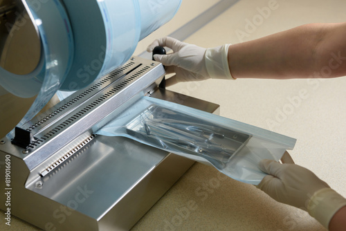 Sterilization of dental medical instruments. Dental assistant packs dental equipment into plastic bags for sterilization using a sterilization roll packaging machine for sterilized dental instruments.
