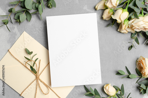 Wedding invitation or greeting card mockup with envelope and roses flowers on grey background