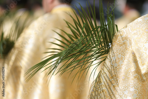Bucharest, Romania - April 27, 2024: Romanian Orthodox priests holding palm leaves walk on the streets of Bucharest during a Palm Sunday pilgrimage procession.