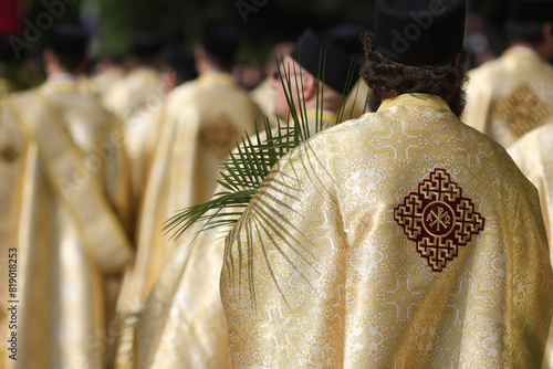 Bucharest, Romania - April 27, 2024: Romanian Orthodox priests holding palm leaves walk on the streets of Bucharest during a Palm Sunday pilgrimage procession.