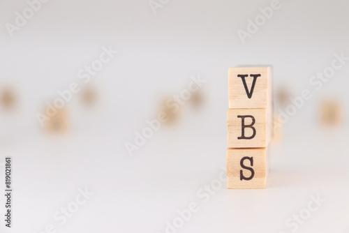 VBS letters. Concept of Vacation Bible School written on wooden cubes isolated on white background.