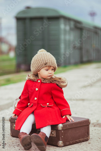 Charming baby girl who is waiting for a train photo